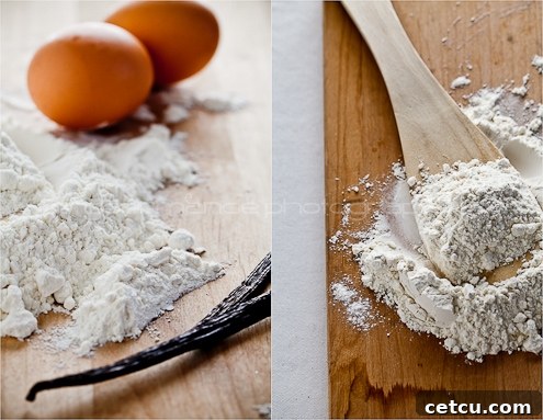 Vanilla beans, flour, and eggs arranged on a rustic surface