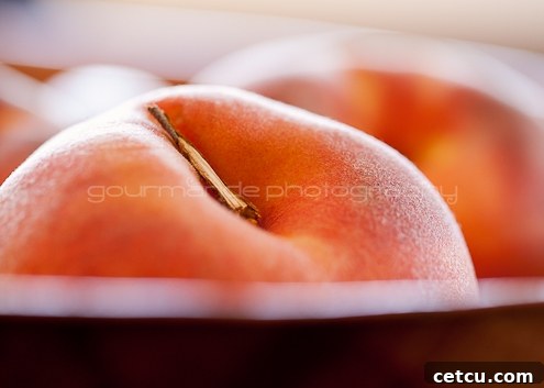 Ripe peaches with dew drops arranged on a rough surface