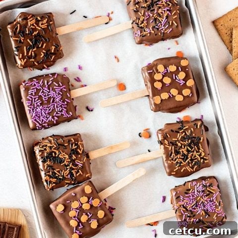 Halloween S'mores Pops with festive sprinkles displayed on a pan.