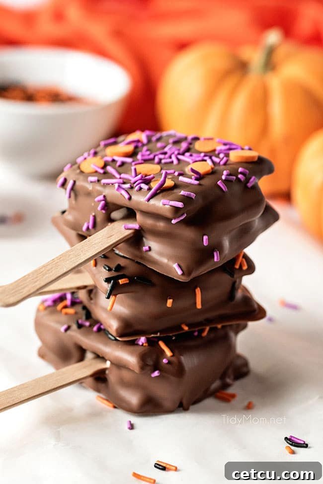 A charming stack of three Halloween S'mores Pops, beautifully decorated with sprinkles, ready to be served.