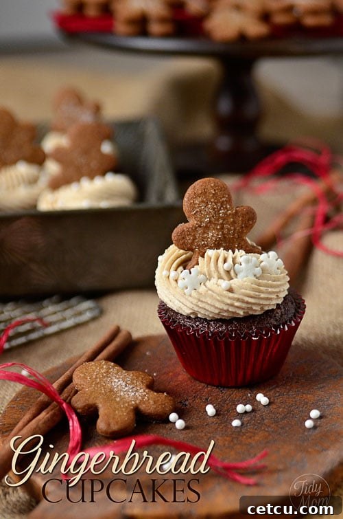 Festive gingerbread cupcake topped with a small, charming gingerbread cookie and a sprinkle of powdered sugar.