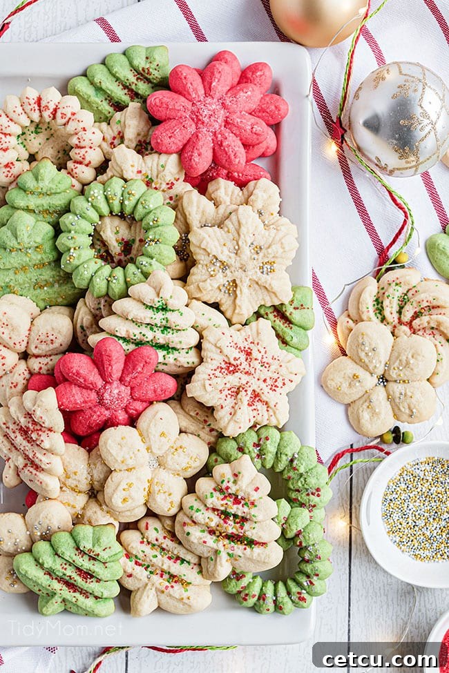 Classic Christmas Spritz Cookies beautifully arranged on a white platter, adorned with festive colors and shapes.