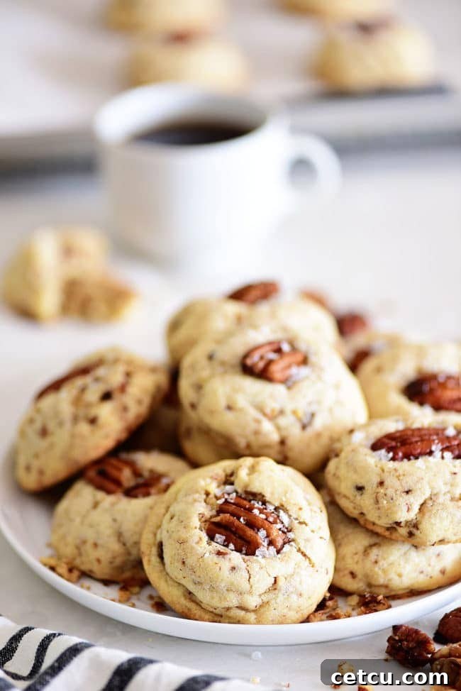 Delicious Butter Pecan Cookies served on a plate with a comforting cup of coffee, perfect for a cozy moment.