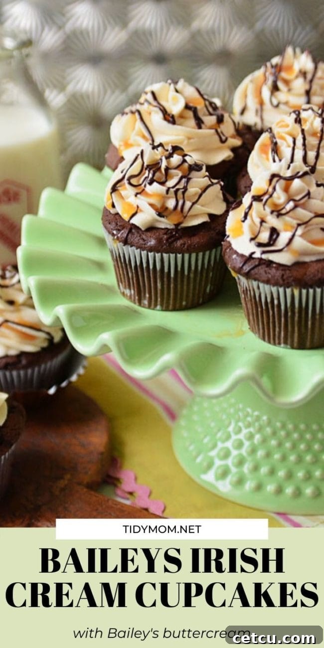 A close-up of Baileys Irish Cream Cupcakes displayed on a green cake stand, highlighting the rich frosting and festive appeal.
