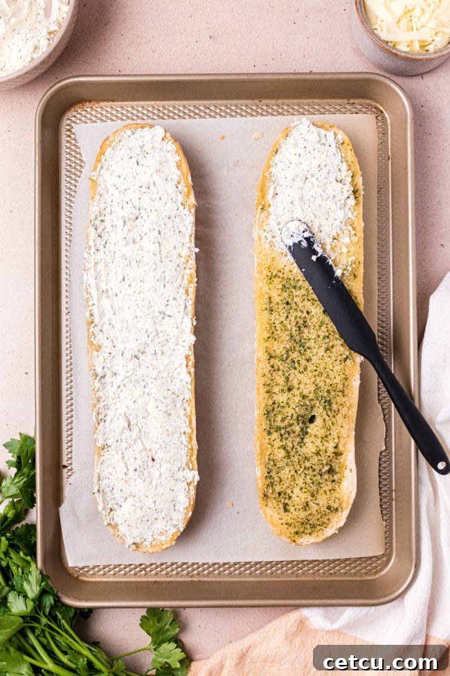 The warm, garlic-buttered French bread halves with the creamy cheese mixture being spread generously over them.