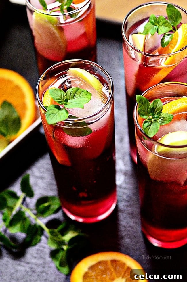 Refreshing pomegranate spritzers garnished with fresh lemon and lime slices, showcasing their vibrant color and effervescence.