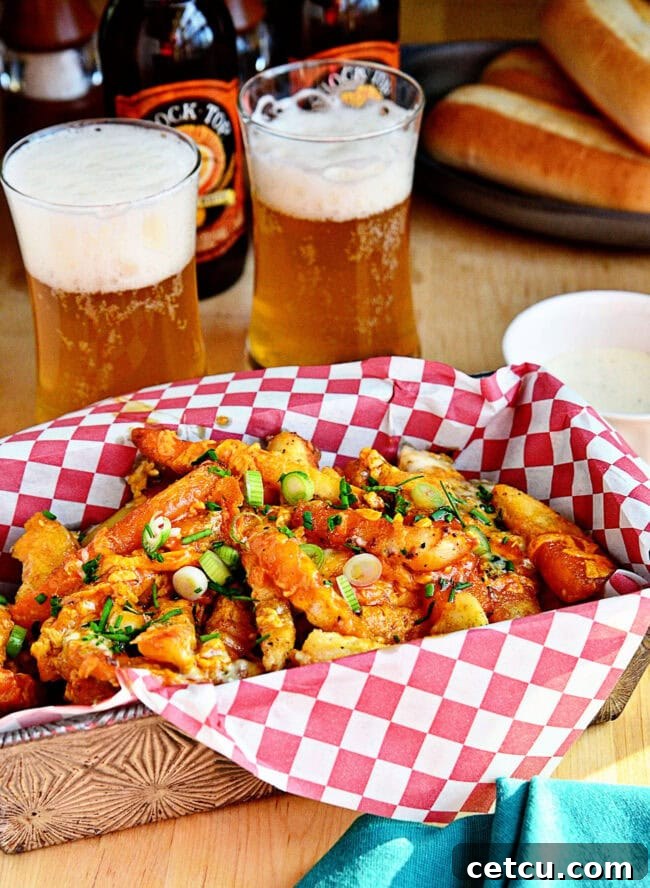 A basket of perfectly golden and cheesy buffalo french fries, drizzled with buffalo sauce and garnished with green onions.