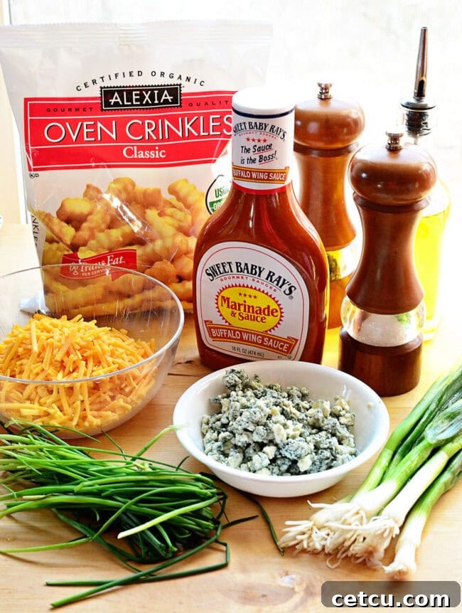 Ingredients laid out for making buffalo cheese fries, including frozen fries, cheeses, buffalo sauce, butter, and seasonings.