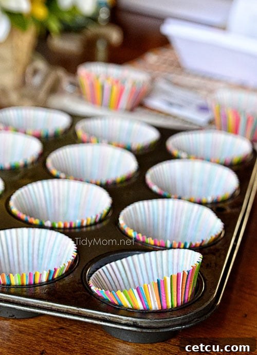 Muffin tin lined with colorful cupcake liners, ready for batter.