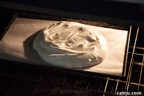 Meringue cooking slowly inside an oven at a low temperature, slowly drying out.
