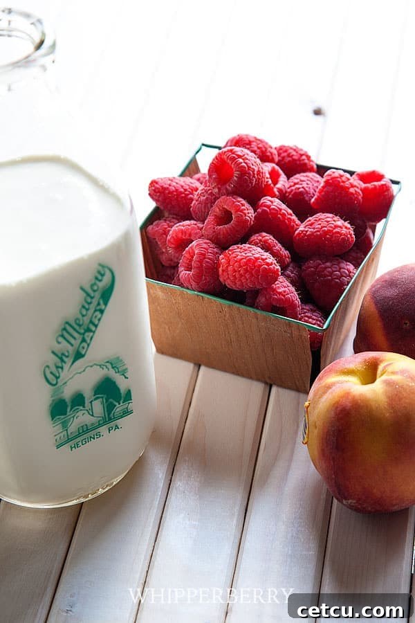 Ingredients for Peach Melba Pavlova: Fresh peaches, raspberries, and a bowl of thick whipped cream.