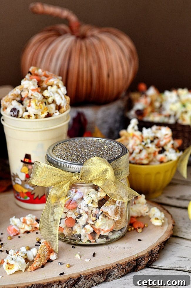 Turkey Munch - Fall Popcorn Snack Mix with bugles, Reeses pieces and sprinkles all drizzled in white chocolate and pumpkin candy melts. Perfect for gifting or at childrens table on Thanksgiving Recipe at Tidymom.net