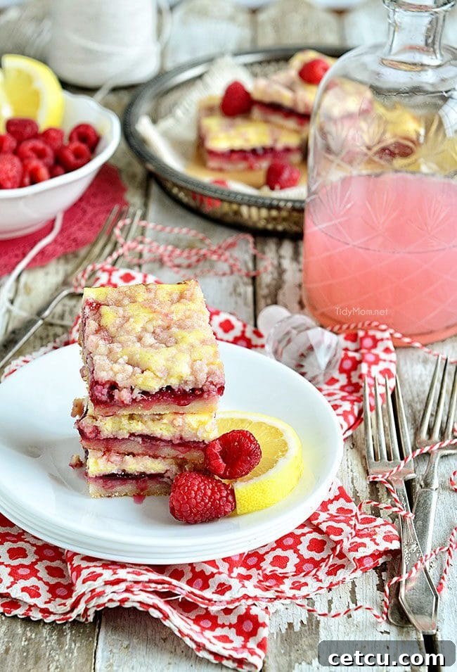 Zesty Raspberry Lemon Squares 4 A tray of freshly baked Raspberry Lemonade Bars, with some pieces cut, highlighting the beautiful layers and golden streusel.