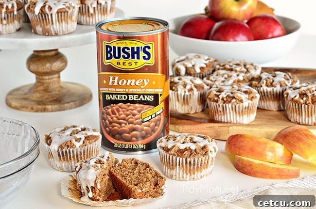 Freshly baked Apple Spice Muffins with Streusel Topping next to a can of Bush's Baked Beans, highlighting the secret ingredient.