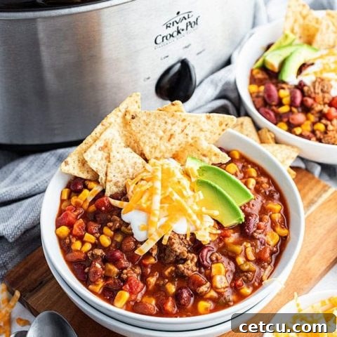 A comforting bowl of Slow Cooker Taco Soup next to the slow cooker, ready to serve.
