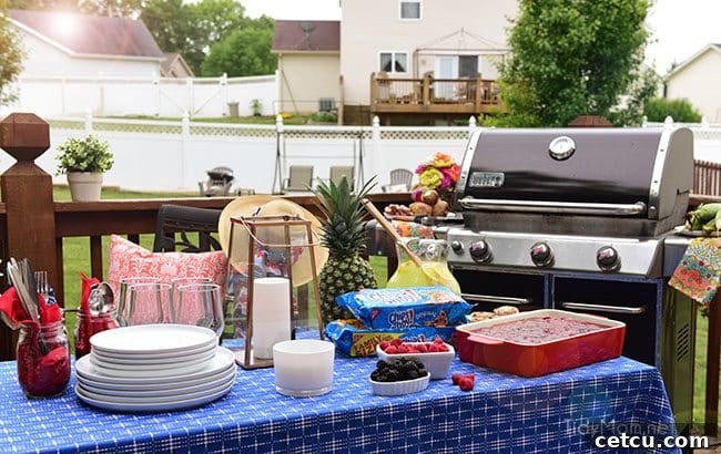A delightful outdoor table setting with fresh flowers and drinks, emphasizing comfortable summer entertaining.