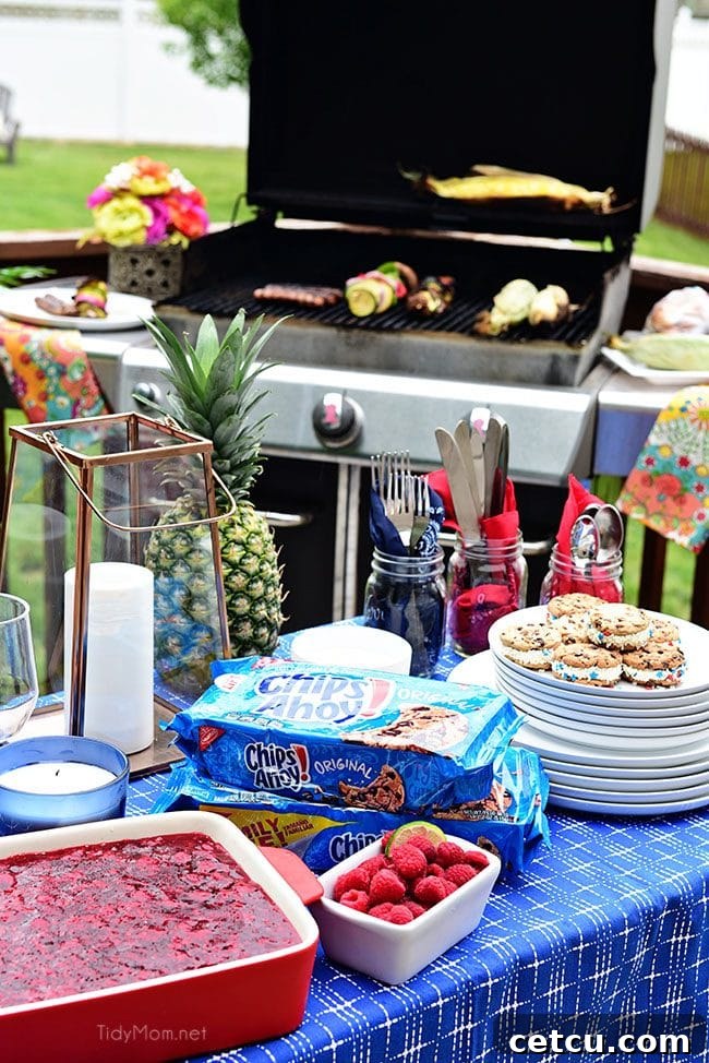 A person grilling various foods on a backyard BBQ, surrounded by summer greenery.