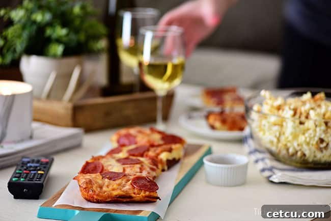 A close-up shot of two glasses of wine, perfectly paired with a relaxing movie night featuring DIGIORNO pizza and homemade Sweet Heat Maple-Chili Popcorn. This image evokes the perfect ambiance for an easy and delicious date night at home. Recipe for popcorn on TidyMom.net.