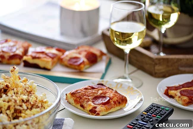 Elevate your Movie Night with gourmet popcorn and oven-ready pizza. This image showcases a spread of Sweet Heat Maple-Chili Popcorn, delicious DIGIORNO pizza, and drinks, setting the scene for a perfect at-home date or family night. Find the gourmet popcorn recipe on TidyMom.net