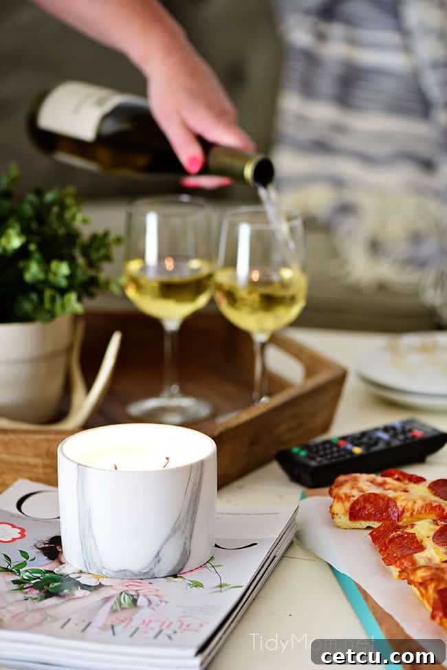 Pouring wine into glasses for a romantic at-home movie night, featuring oven-ready DIGIORNO pizza and homemade Sweet Heat Maple-Chili Popcorn. This image sets the ambiance for a relaxed and special evening. Get the gourmet popcorn recipe at TidyMom.net.