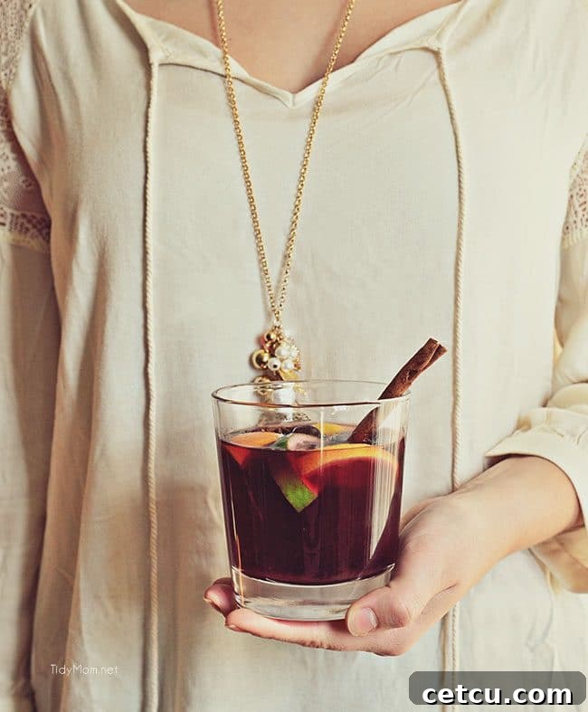 A festive glass of Mulled Wine (Glühwein), garnished with an orange slice and cinnamon stick, evoking the warmth and spirit of the holiday season.