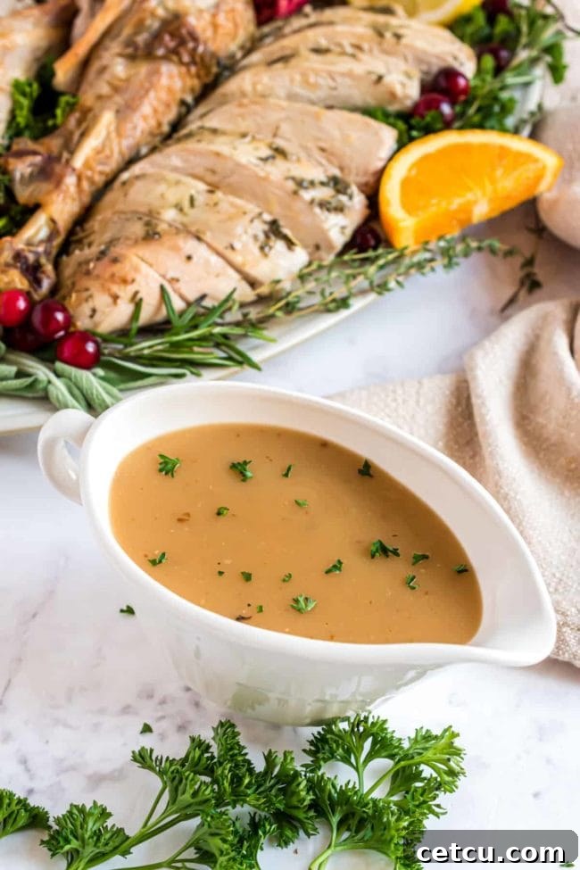 A serving of rich, homemade turkey gravy poured over sliced turkey, enhancing the main course of a Thanksgiving meal.
