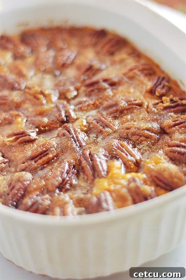 Pecan Topped Sweet Potatoes from Your Homebased Mom, presented in a baking dish with a golden-brown, nutty crust.