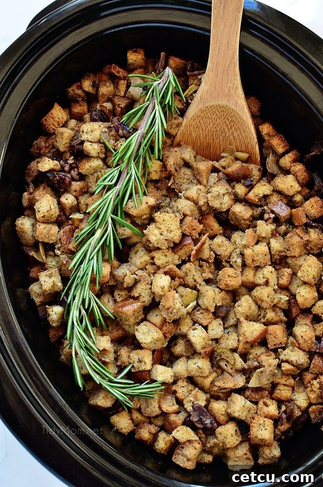 Slow Cooker Stuffing with artichokes, mushrooms, and toasted pecans, served in a festive bowl, highlighting its moist and flavorful appeal.