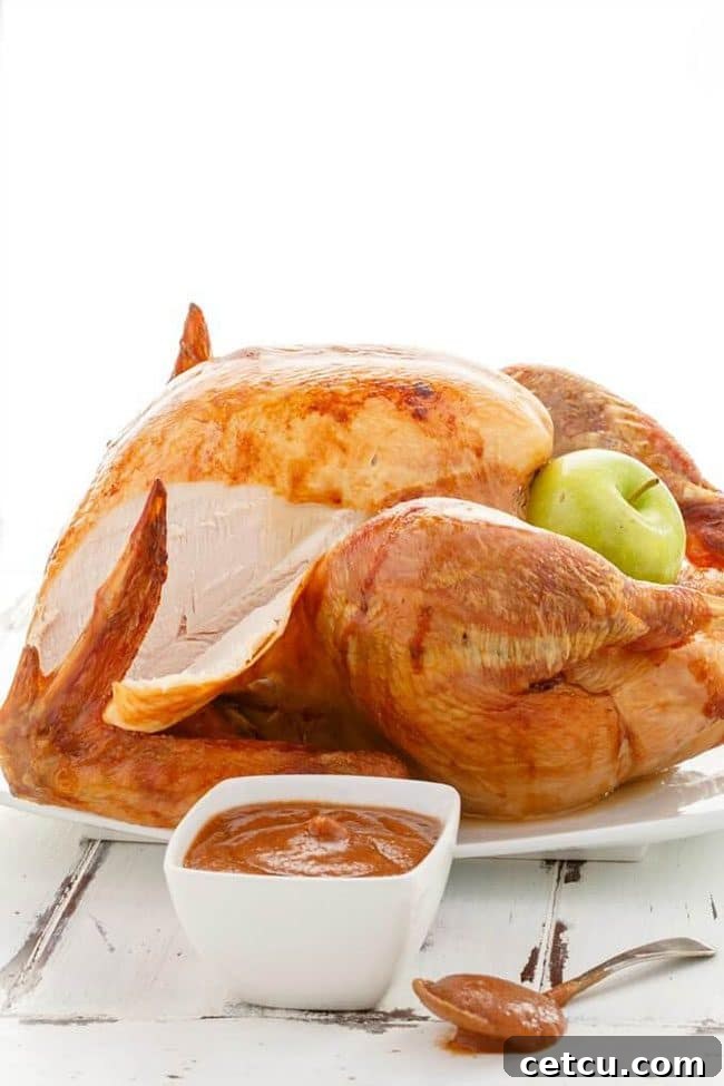 Roasted Apple Butter Turkey from The Cookie Writer, presented on a platter with a beautiful golden crust.