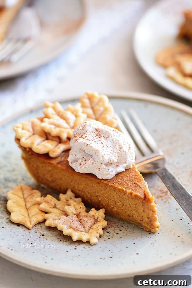 A beautifully baked Homemade Pumpkin Pie with decorative leaf cut-outs on the crust, ready to be served as a classic Thanksgiving dessert.
