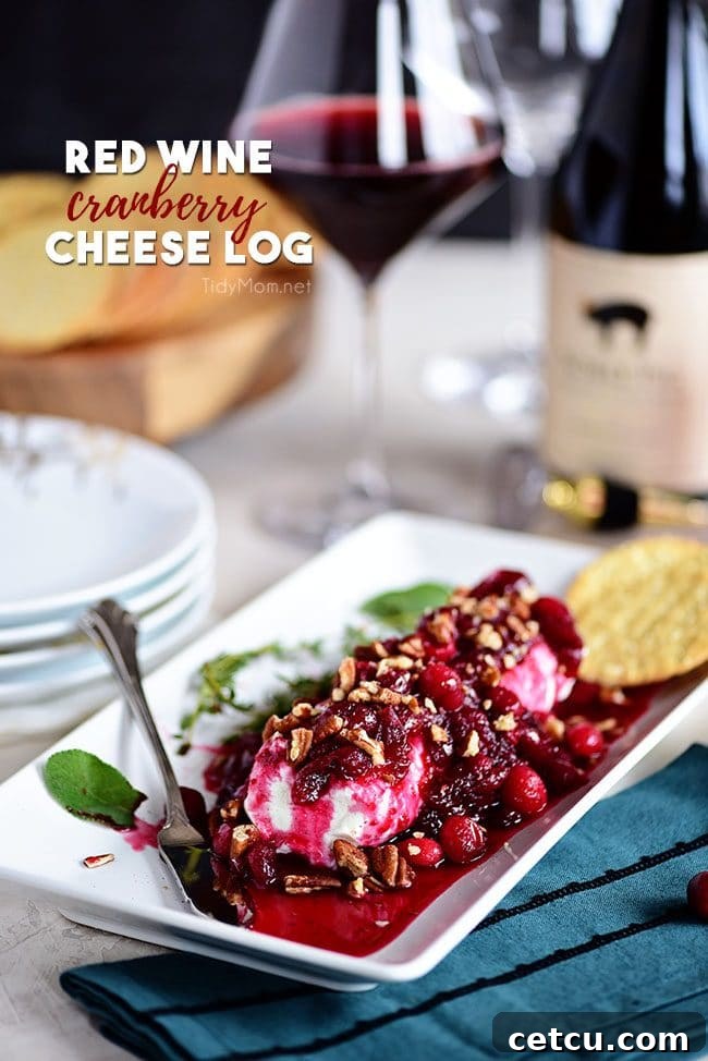 A Red Wine Cranberry Cheese Log appetizer served on a platter with crackers and a bottle of wine in the background, perfect for holiday entertaining.