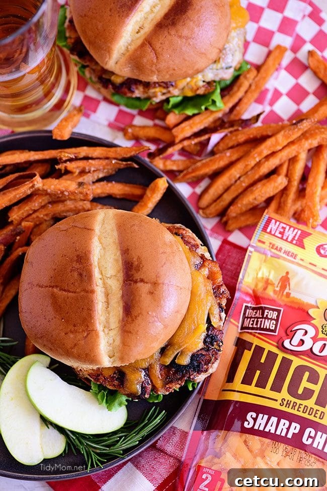 Close-up of Apple Cheddar Pork Burgers with rosemary and sharp cheddar, emphasizing the unique flavor combination that elevates burger night.