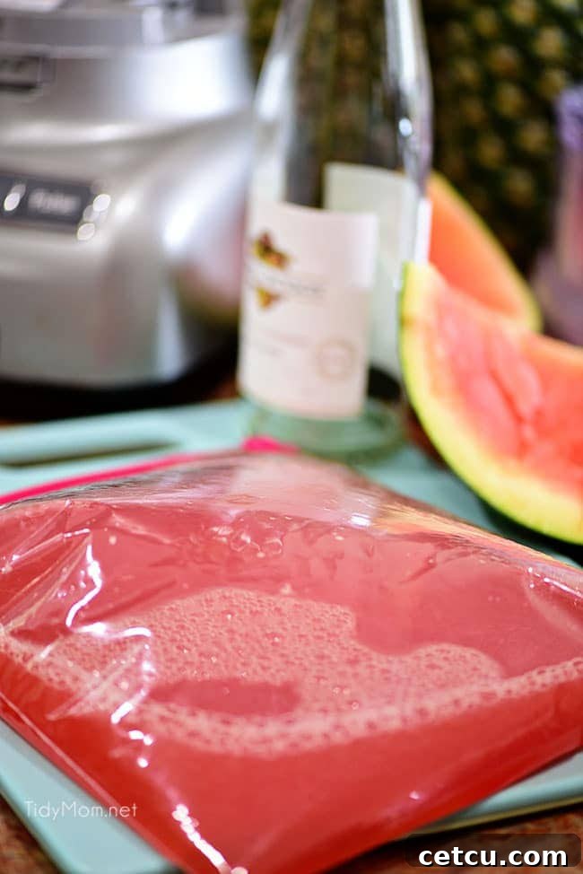 A large zip-top bag filled with the red watermelon and wine mixture, ready to be placed in the freezer to make Watermelon Grapefruit Wine Slush.