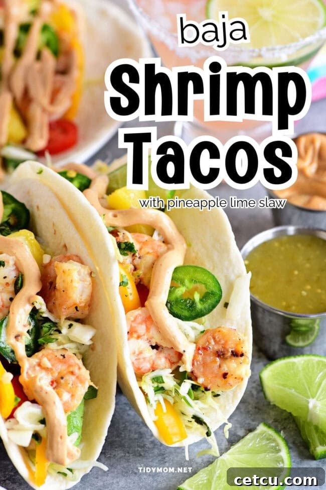 Two Baja Shrimp Tacos served in soft flour tortillas on a white plate