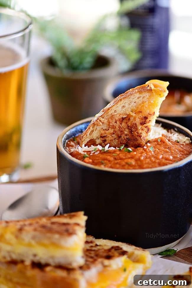 Roasted Tomato Soup in a black mug with grilled cheese sandwich