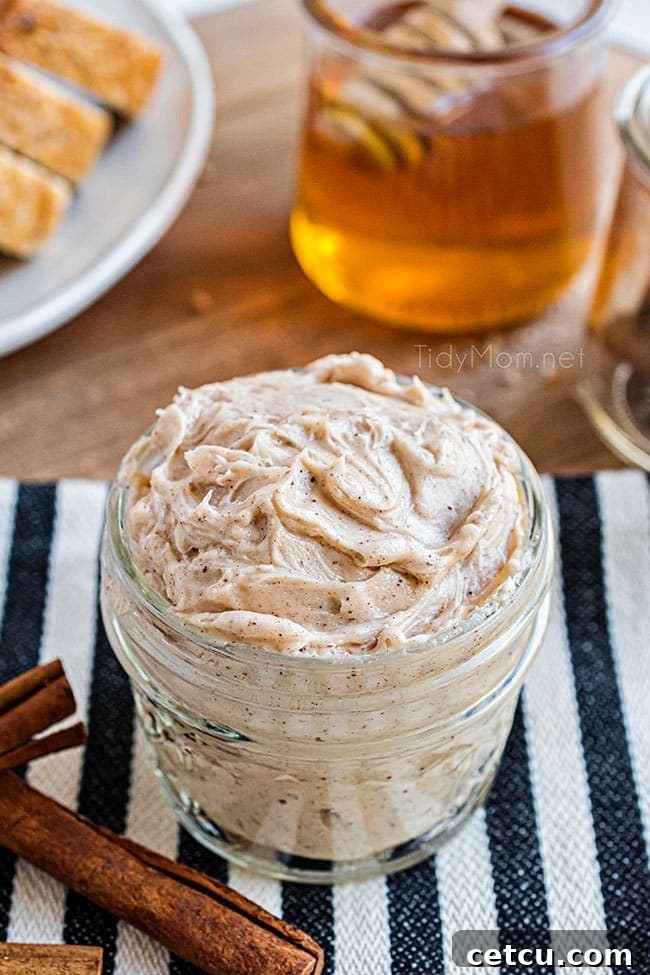 A half-pint jar of homemade cinnamon honey butter, creamy and golden, ready to be served.