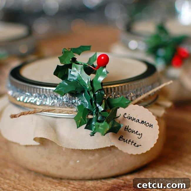Beautifully presented handmade food gift of Cinnamon Honey Butter in a jar, paired with homemade bread and a decorative towel, perfect for holidays.