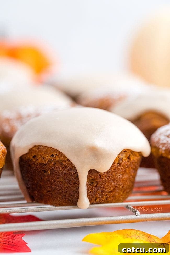 a close-up of a pumpkin muffin with maple glaze dripping down its sides, highlighting its delicious texture