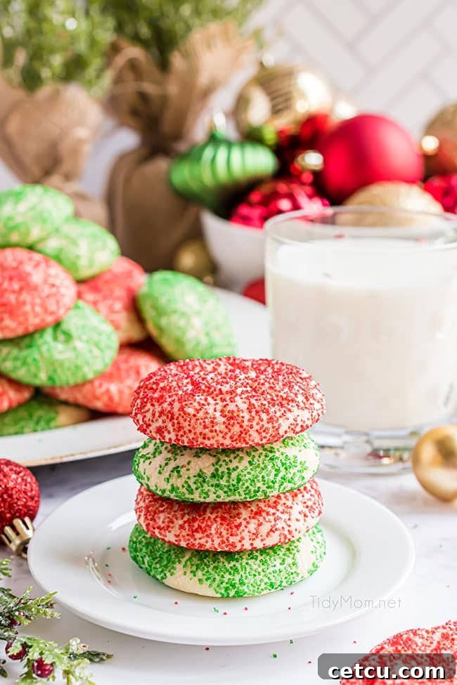 A stack of four soft, thick, and chewy Christmas drop sugar cookies rolled in bright green and red sanding sugar, beautifully arranged on a festive holiday table.