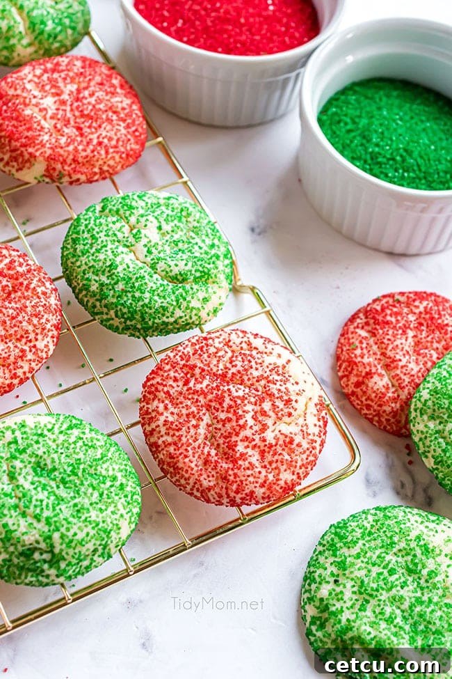 Freshly baked Christmas drop sugar cookies cooling on a wire rack, showing their vibrant red and green sanding sugar and perfectly set edges.