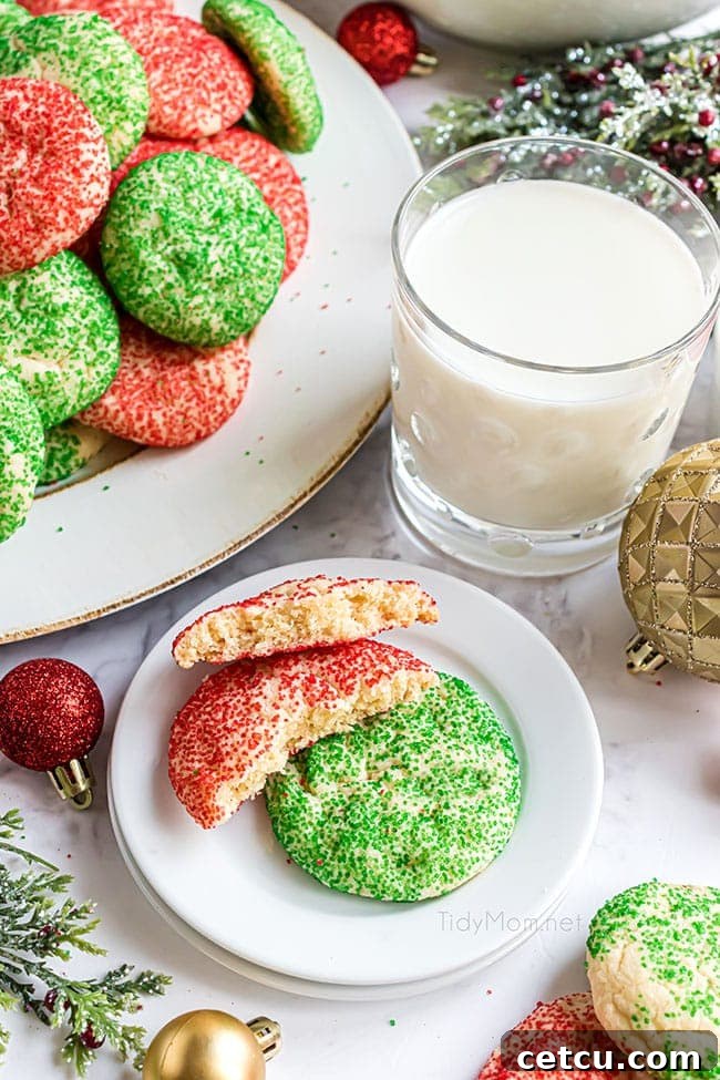 A festive plate of red and green Christmas drop cookies, with one cookie perfectly broken in half to reveal its soft, chewy interior.