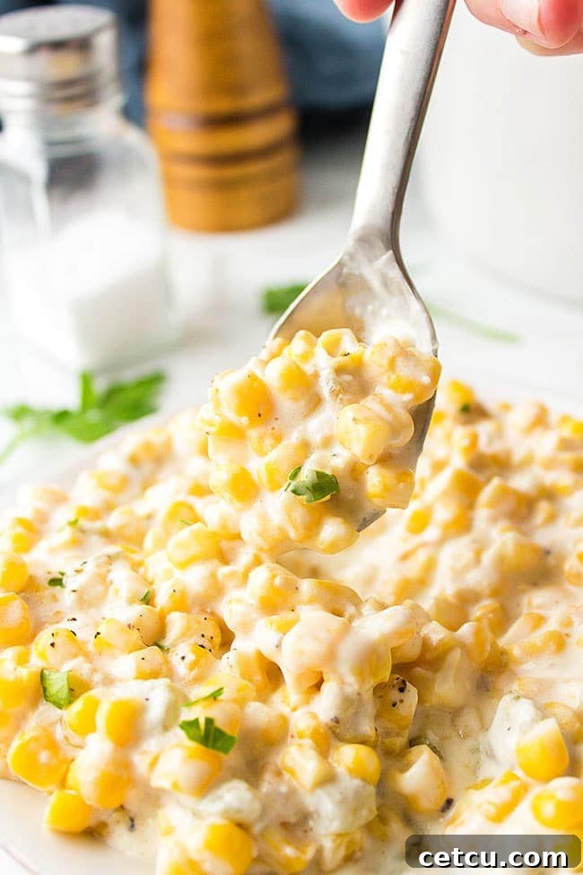 Creamed Corn on a spoon over a plateful.