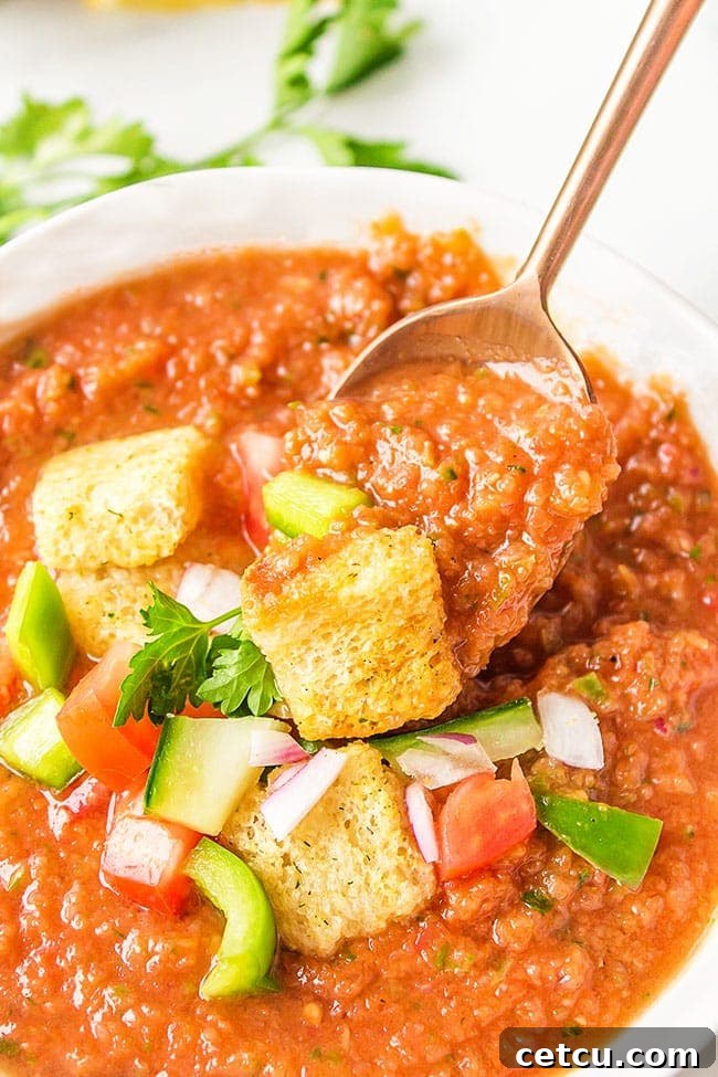 spoonful of summer gazpacho in a white bowl