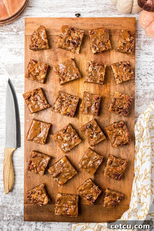 Autumn's Magical Seven Layer Pumpkin Bars 7 neatly cut Pumpkin Magic Bars arranged on a rustic wood board