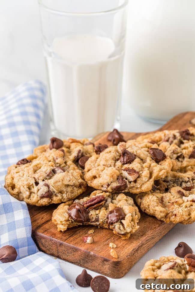 a rustic board piled high with freshly baked Ranger Cookies, alongside a refreshing glass of milk, ready for enjoyment.