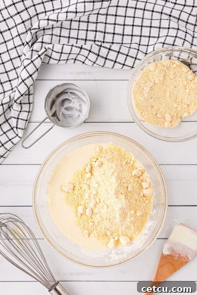 Step 2: Adding sour cream to the wet ingredients for Jiffy cornbread.
