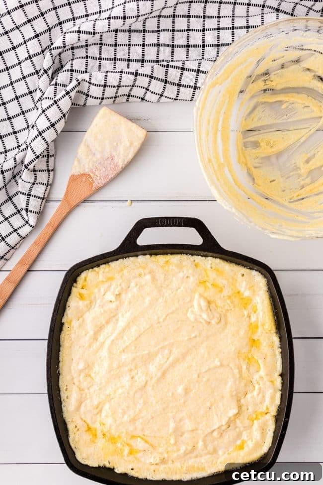 Step 5: Pouring the Jiffy cornbread batter into a hot cast iron skillet.