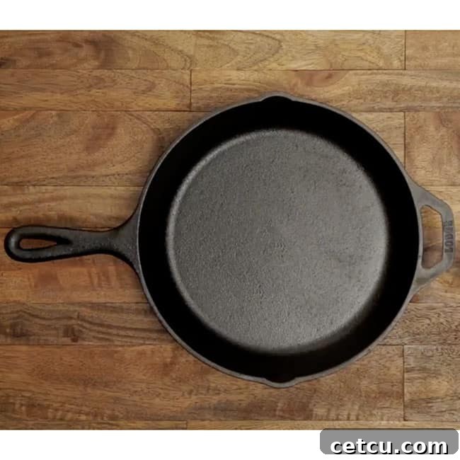 A classic, well-seasoned 12-inch cast iron skillet resting on a rustic wooden table, ready for cooking.
