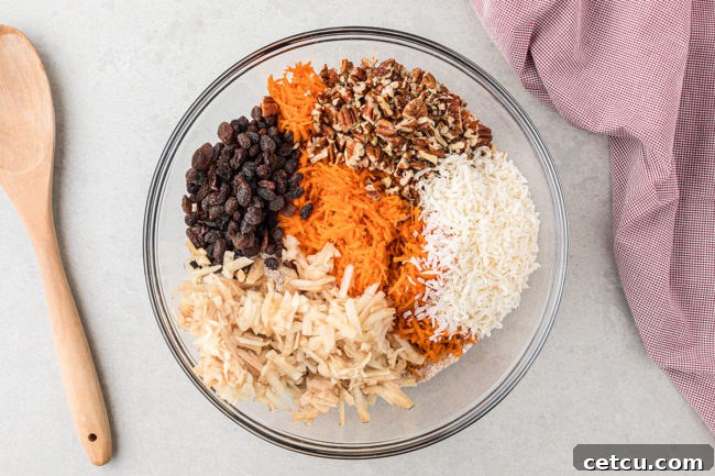 muffin ingredients in a glass mixing bowl with wooden spoon next to it