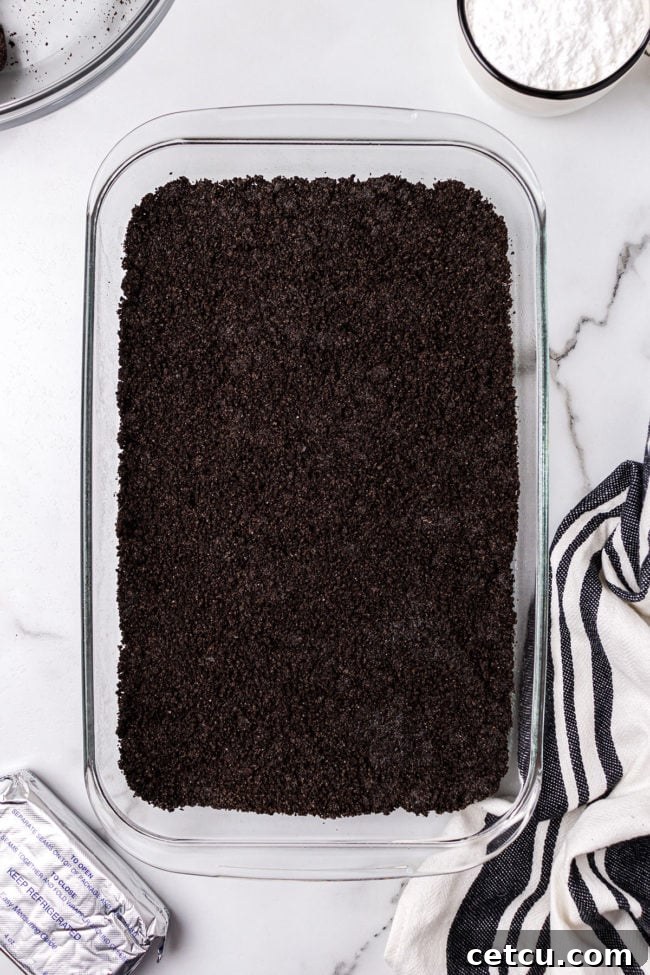 Step 4: Spreading the creamy cream cheese layer evenly over the chilled Oreo crust.